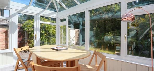 Bright conservatory with dining table and chairs