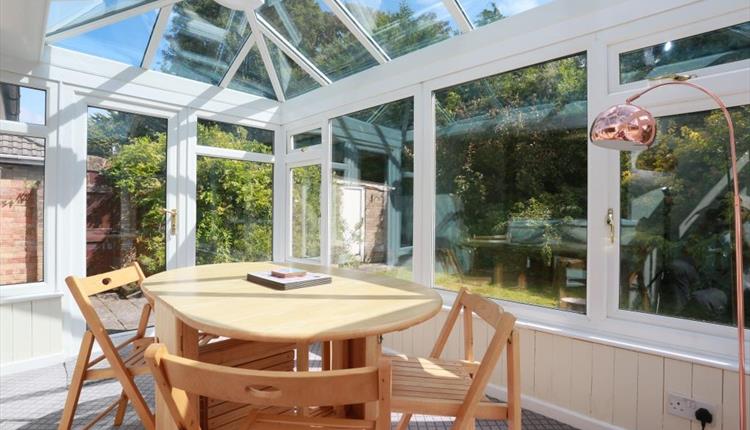Bright conservatory with dining table and chairs