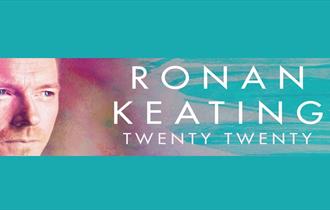 Ronan Keating headshot with blue and purple pastel background.