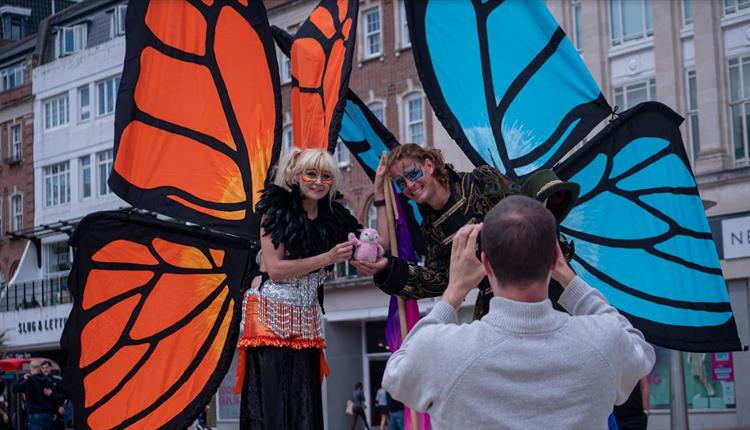 Giant butterfly characters posting for a photograph with the back of the photographer towards the camera