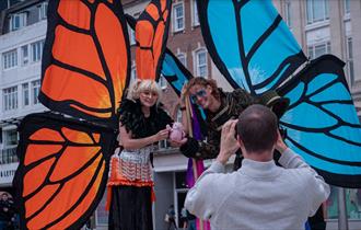 Giant butterfly characters posting for a photograph with the back of the photographer towards the camera