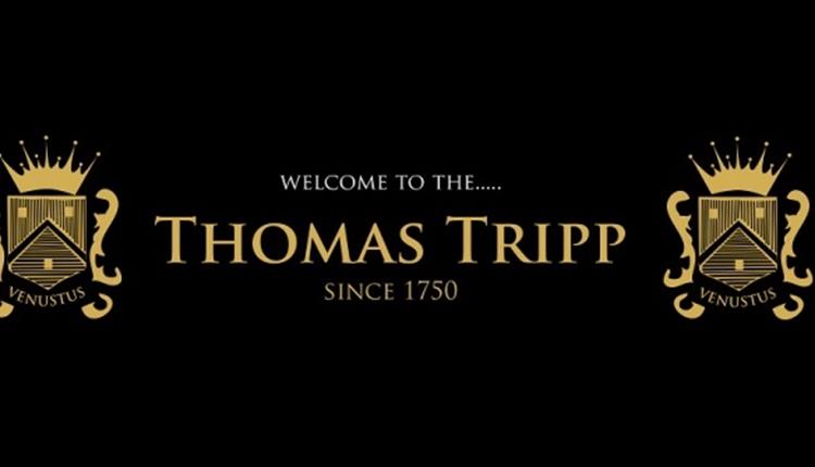 Golden thomas tripp emblems on a black background.