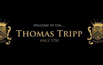 Golden thomas tripp emblems on a black background.