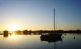 Silhouettes of boats moored in Christchurch Harbour.