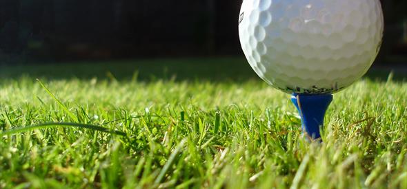 Macro image of golf ball on a blue tee.