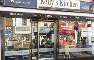 Kelly's Kitchen exterior with Christchurch high street visible in the shop window reflections.